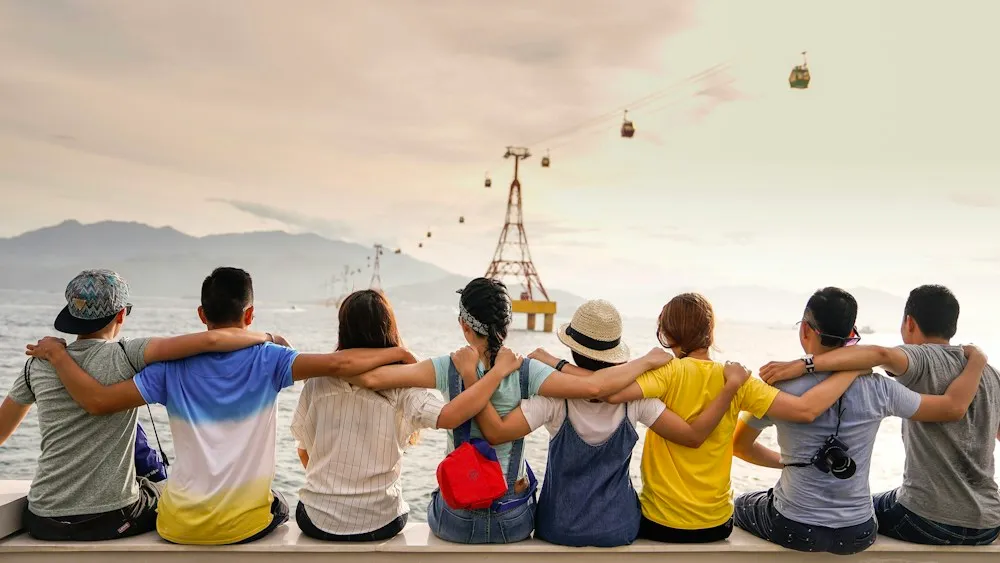 Grupo de amigos abrazados frente al paisaje durante un viaje