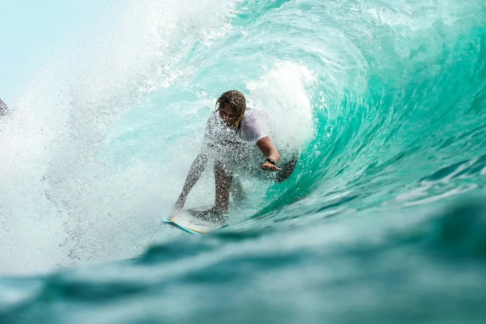 Surfista en una ola de agua turquesa
